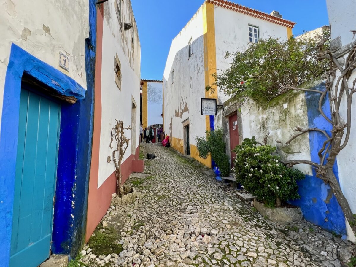 A cobblestone street of white-washed houses in Óbidos Portugal