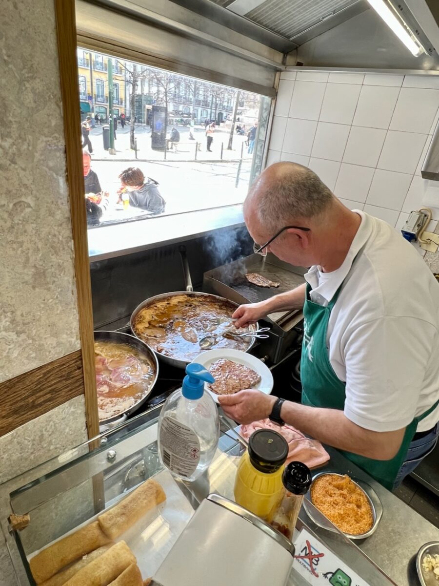Cook preparing a Bifana sandwich at O Trevo in Lisbon Portugal 