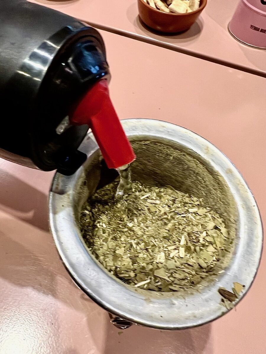 Pouring water into Yerba leaves while preparing Mate