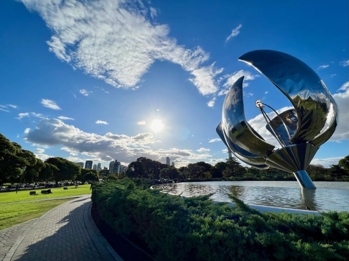 The Floralis Generica sculpture in Buenos Aires Argentina pointing towards the sun with the Palermo neighborhood in the background