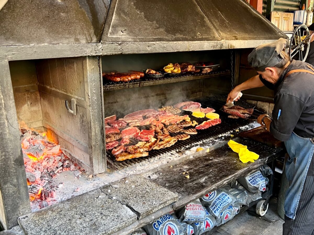 An charcoal grill covered with various kinds of meat at El Gran Paraiso in La Boca