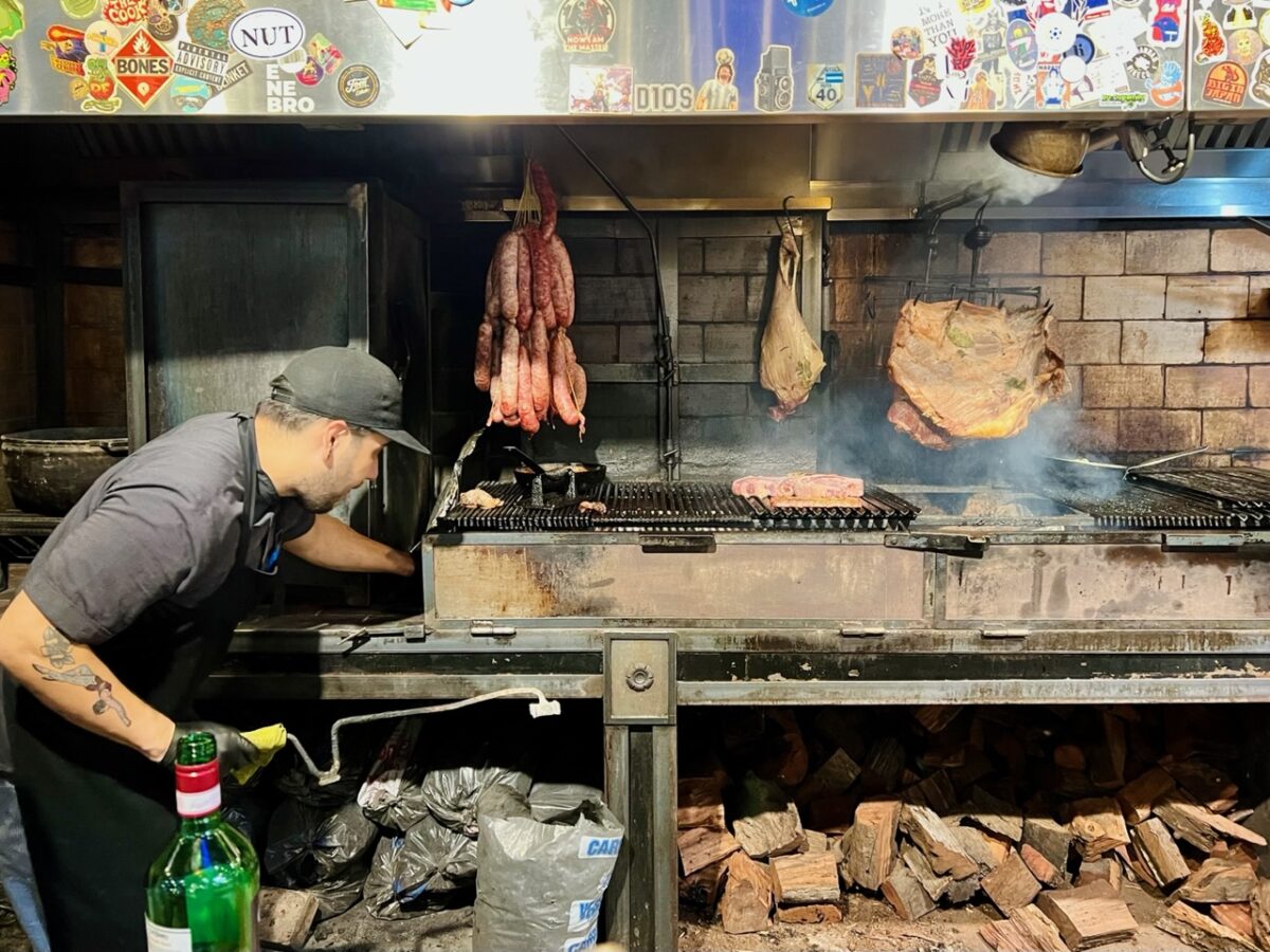 The grill master adjusting the grill at Hierro Parrilla in the San Telmo Market