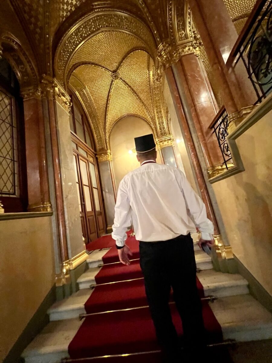 Following a guard up the Golden staircase while touring the Hungarian Parliament in Budapest