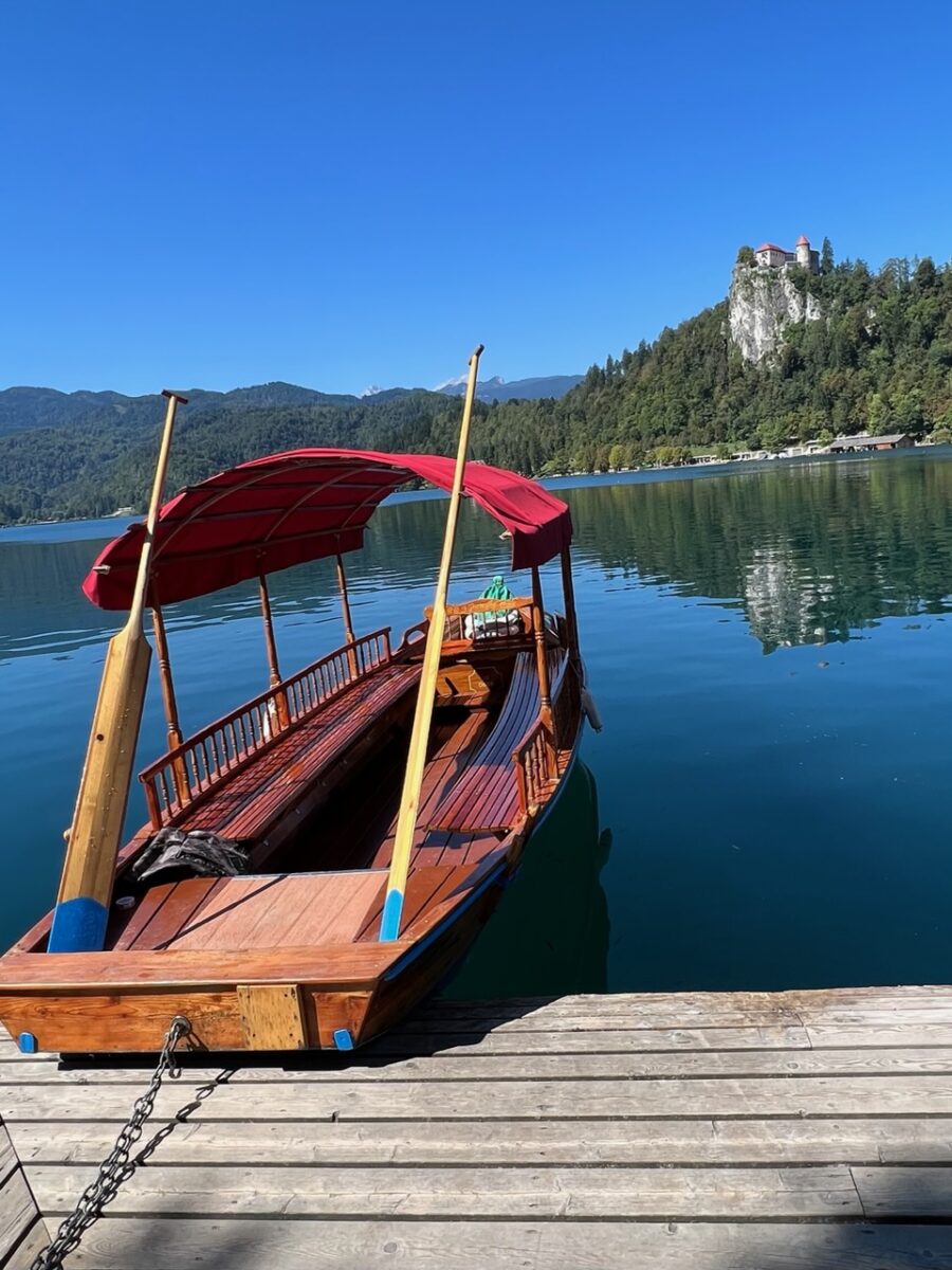 A traditional pletna boat on Lake Bled with Bled Castle in the background
