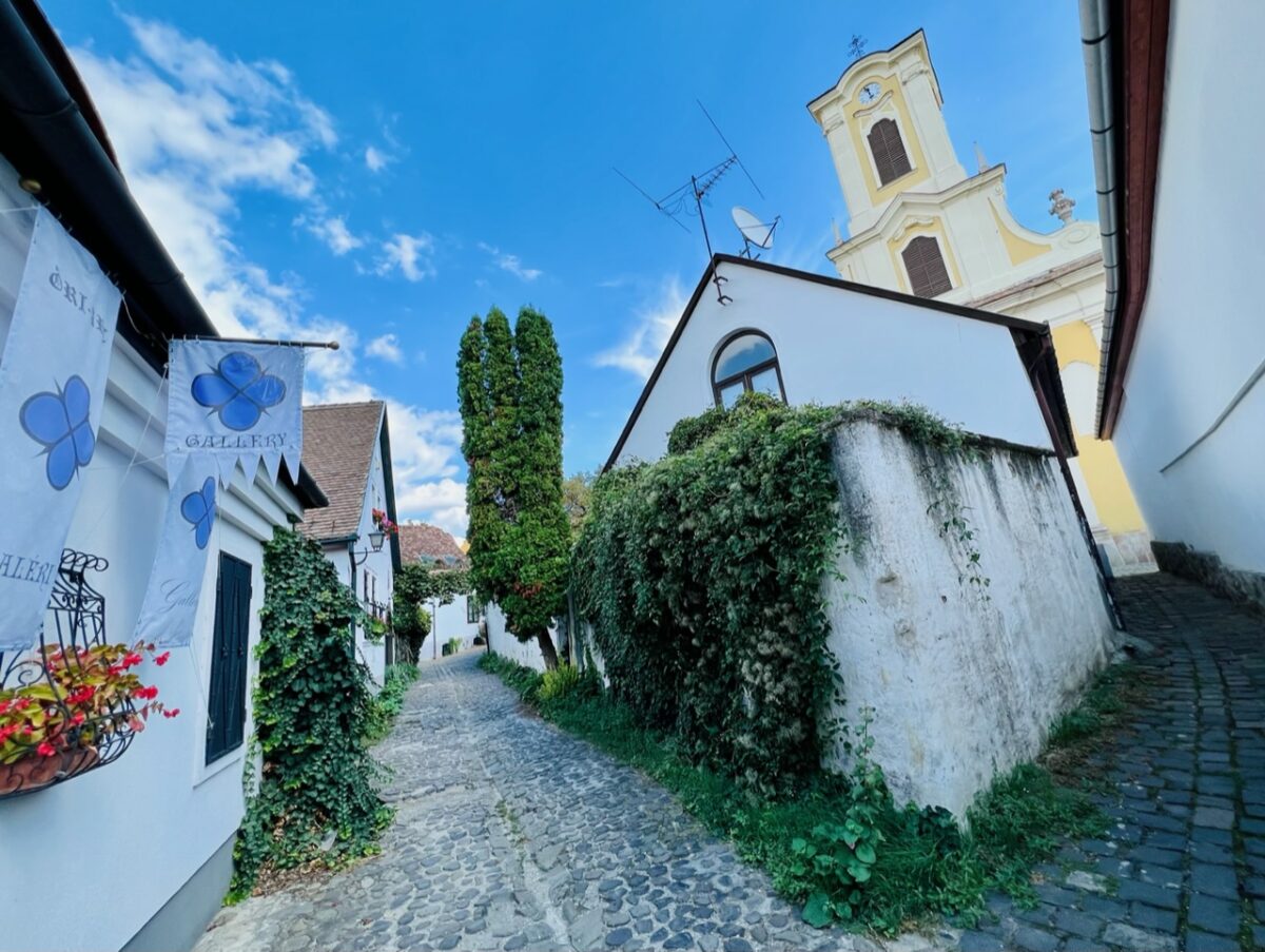 Art galleries, old world architecture, church tower, and cobblestone streets in Szentendre Hungary - an easy day trip from Budapest