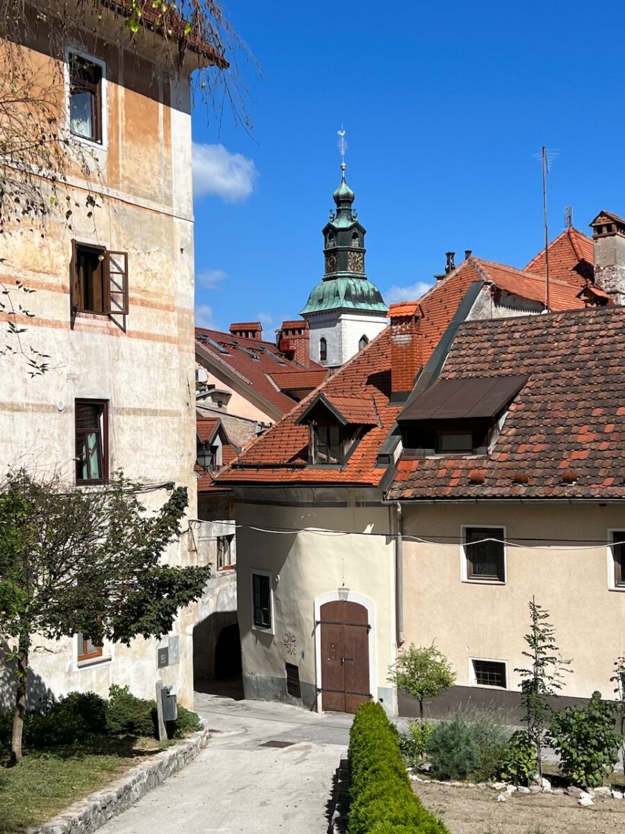 A church tower rises above the rooftops of medieval Skofja Loka Slovenia