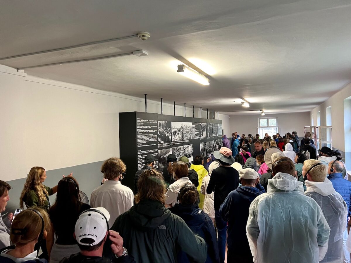 Crowds of people touring the inside of one of the Auschwitz buildings