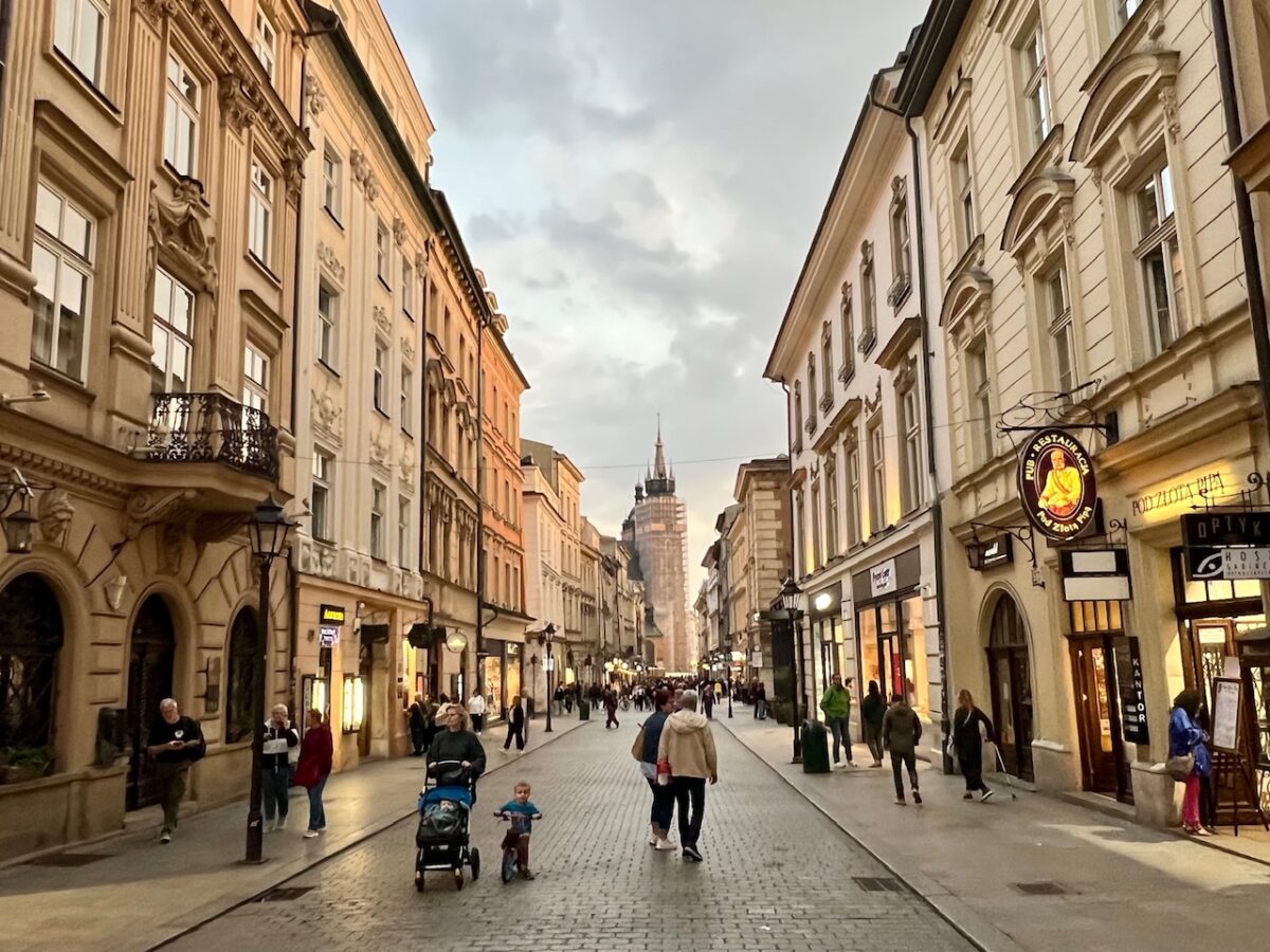 A Street in Old Town Krakow at sunset with lights just coming on the buildings. 