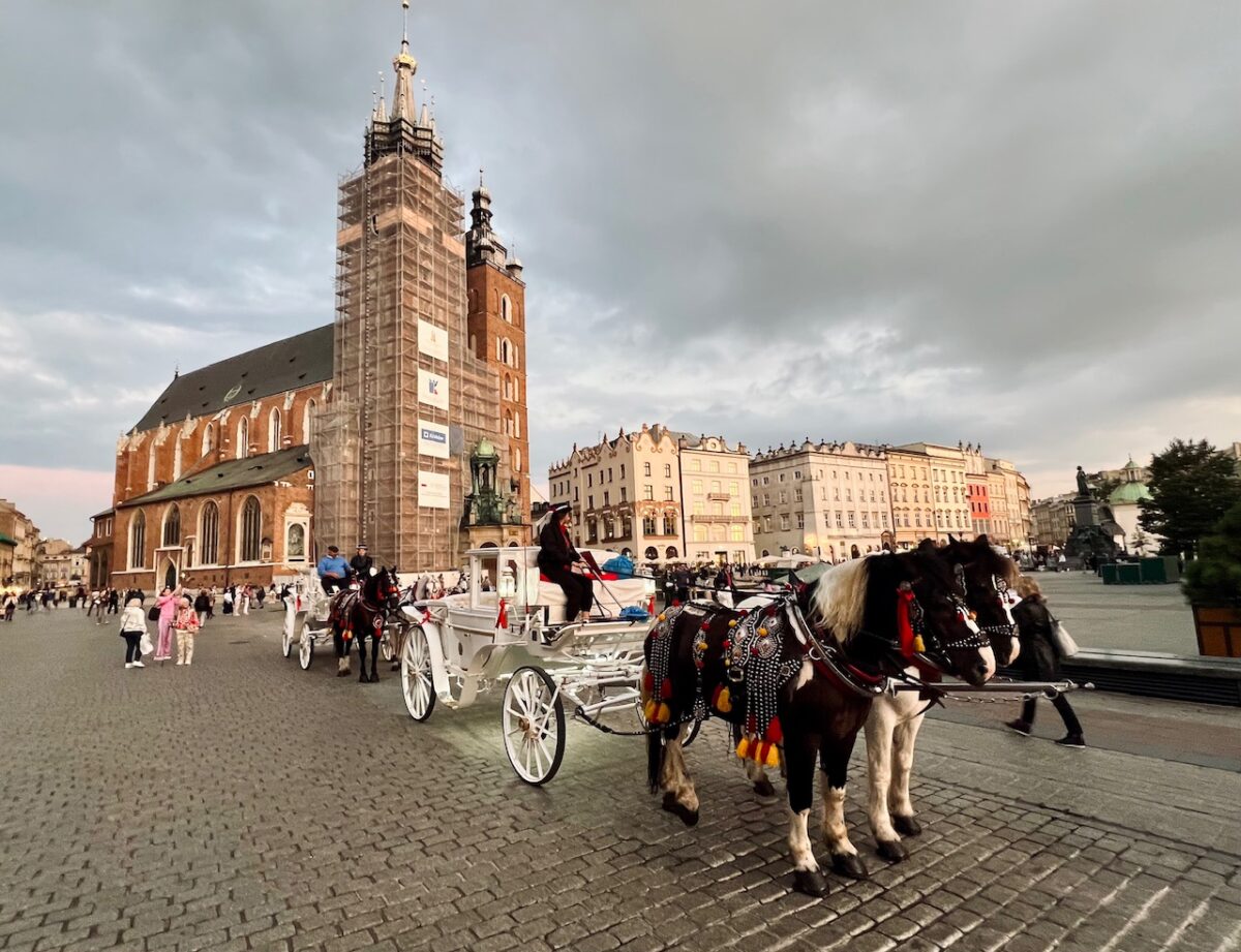 A horse carriage sits in front of St Mary's Basilica in Krakow Poland