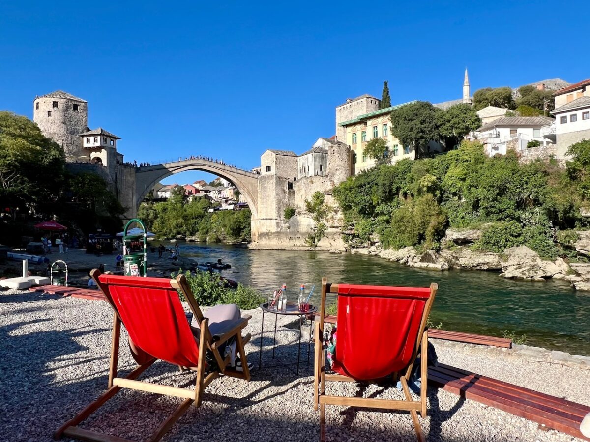 Red deck chairs with a view of the Old Bridge in Mostar from the Old Bridge Lazy Bar