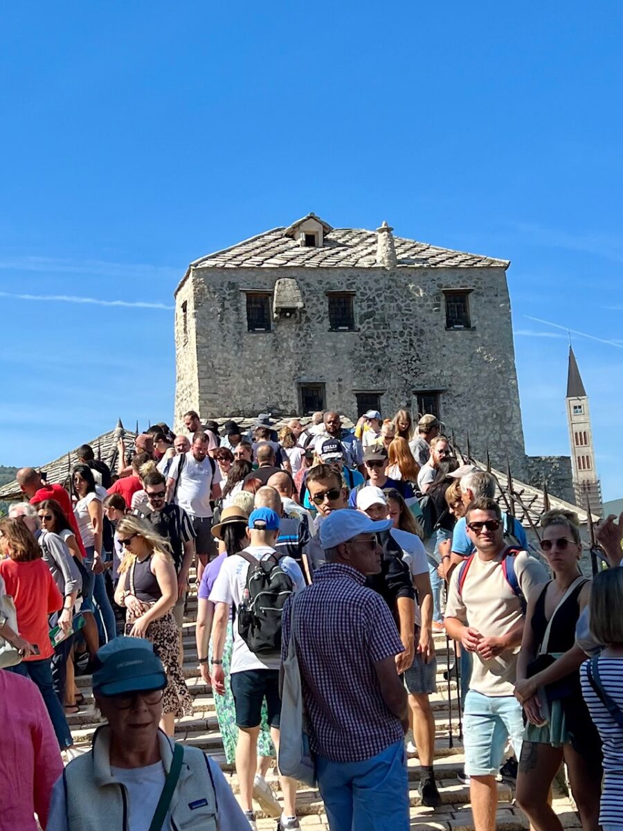 Crowds visiting Mostar walking across the Old Bridge