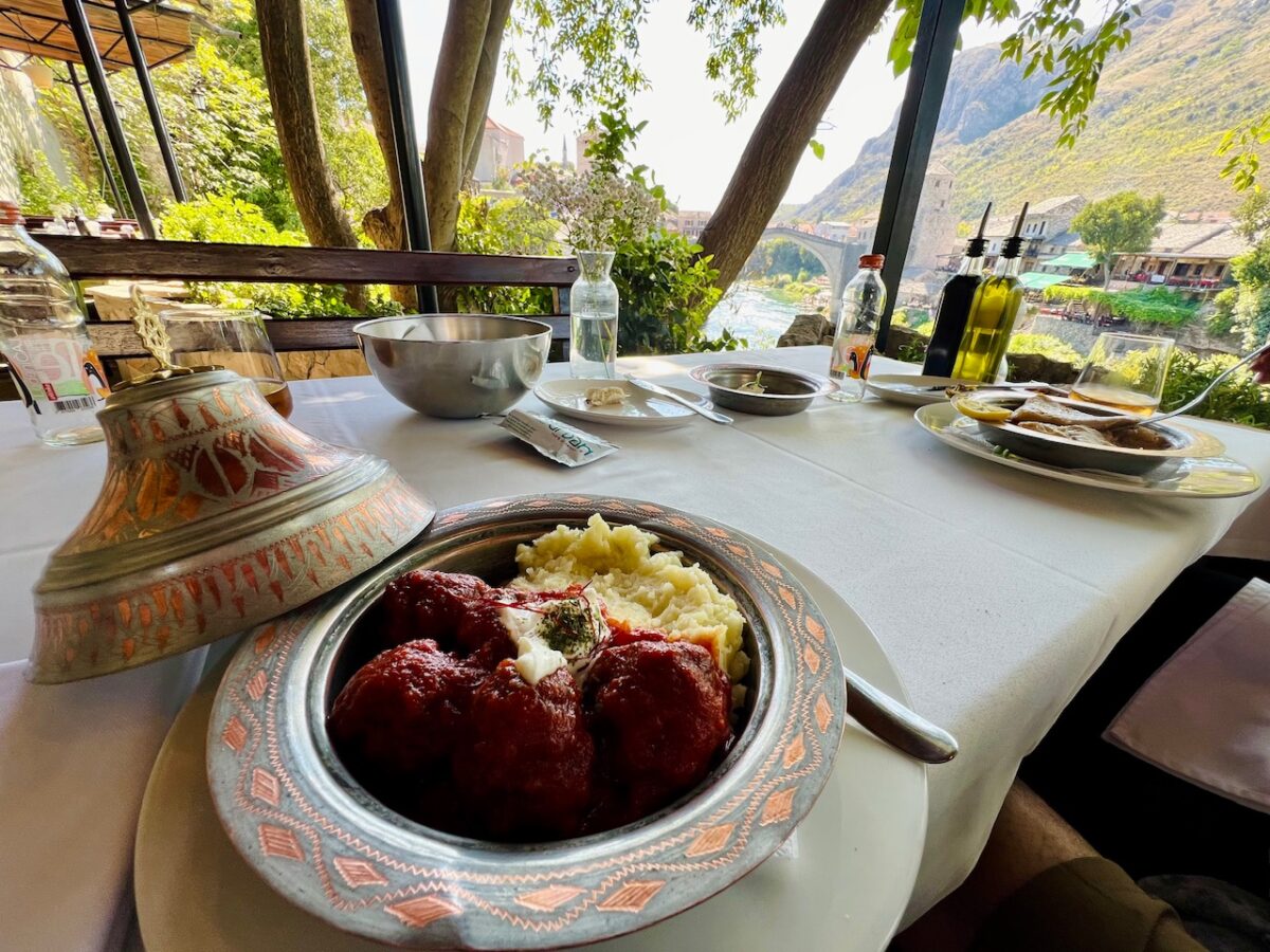 Bosnia meatballs with a distant view of the Mostar bridge from Urban Taste of Orient - a great place to eat when visiting Mostar