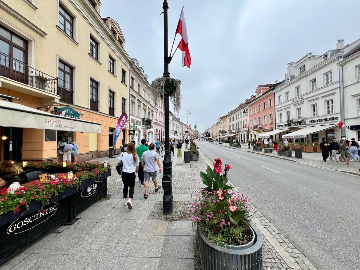 Tourists walking down Nowy Świat Street while visiting Warsaw Poland