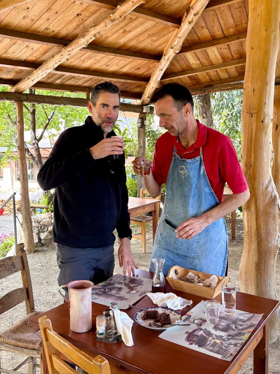 The Thorough Tripper and waiter Stavros drinking homemade wine together at Ntounias in Crete