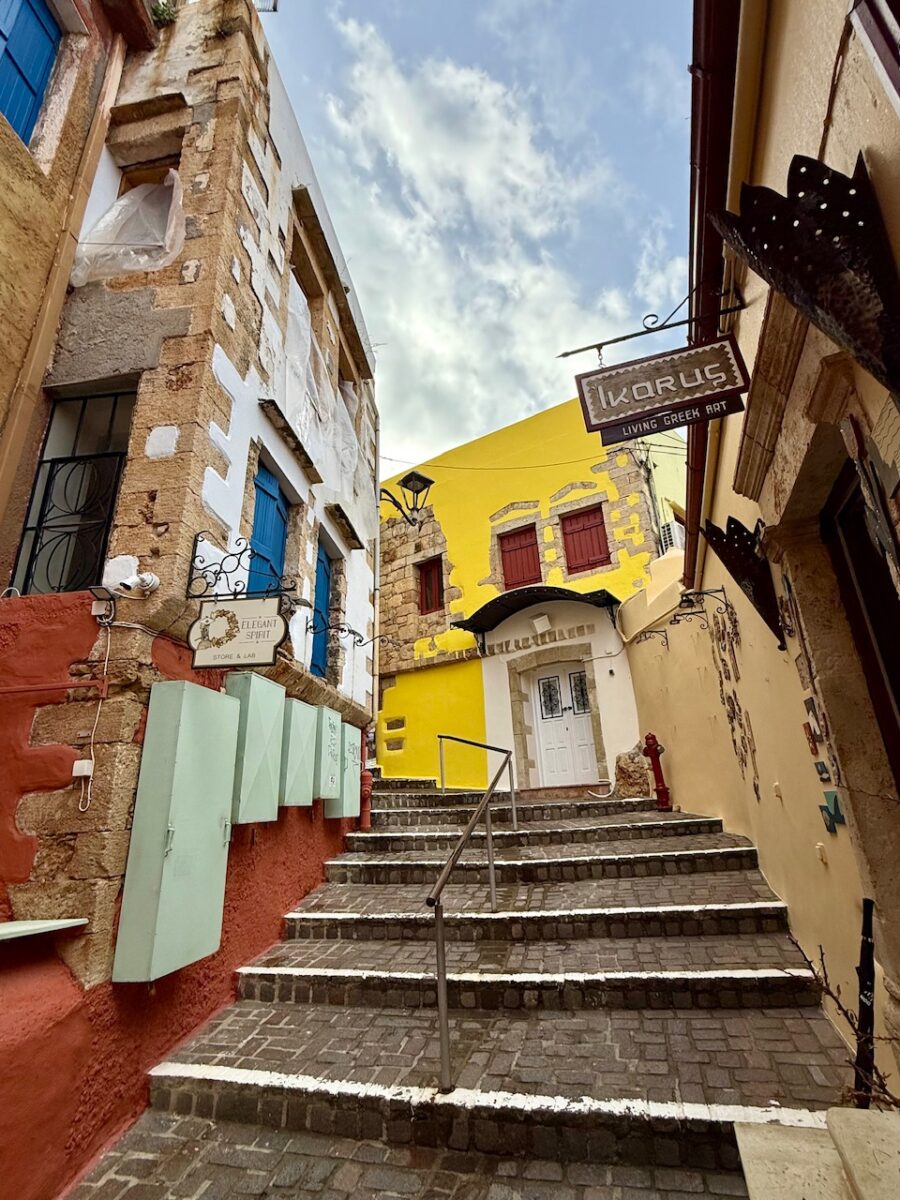Colorful buildings and a staircase in Old Town Chania Crete. When choosing to visit Heraklion or Chania, keep in mind that Chania's Old Town is more scenic