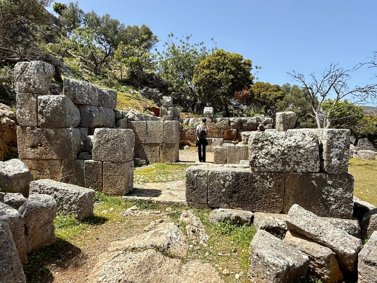 A woman standing inside the ruins of the temple at Ancient Lato in Crete