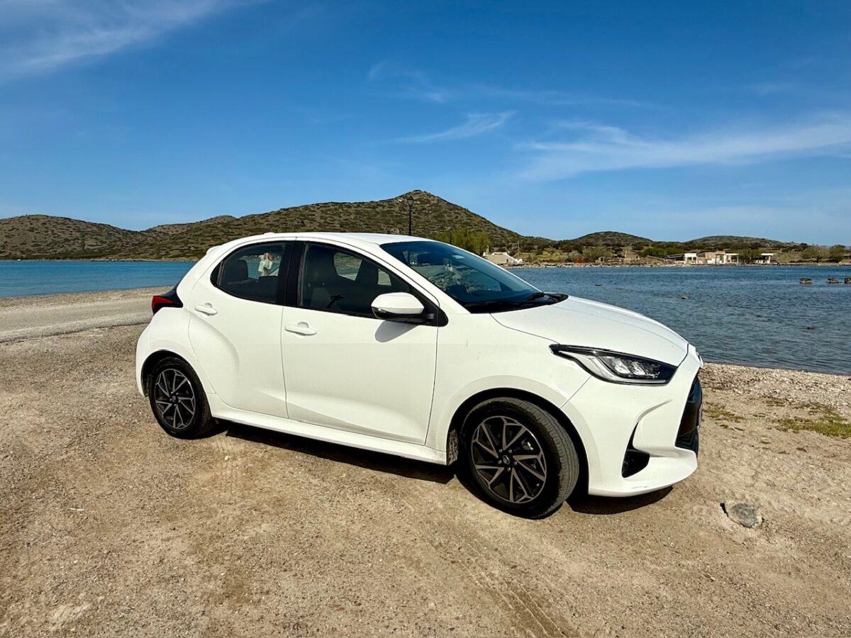 Toyota Yaris from Niki Cars parked next to the Sea in Crete - this type of car is perfect when renting a car in Crete