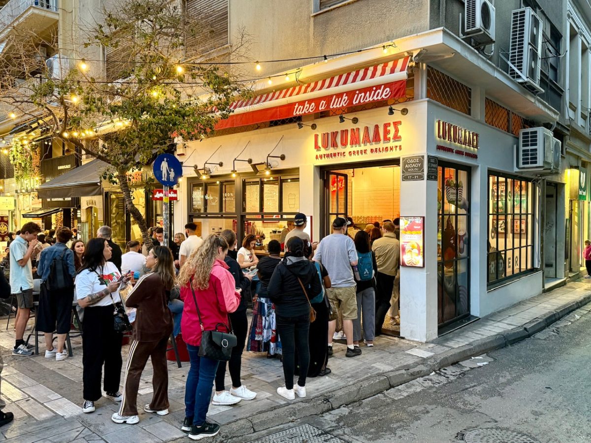 A line of customers outside of LUKUMAΔΕΣ - a loukoumades franchise in Athens 