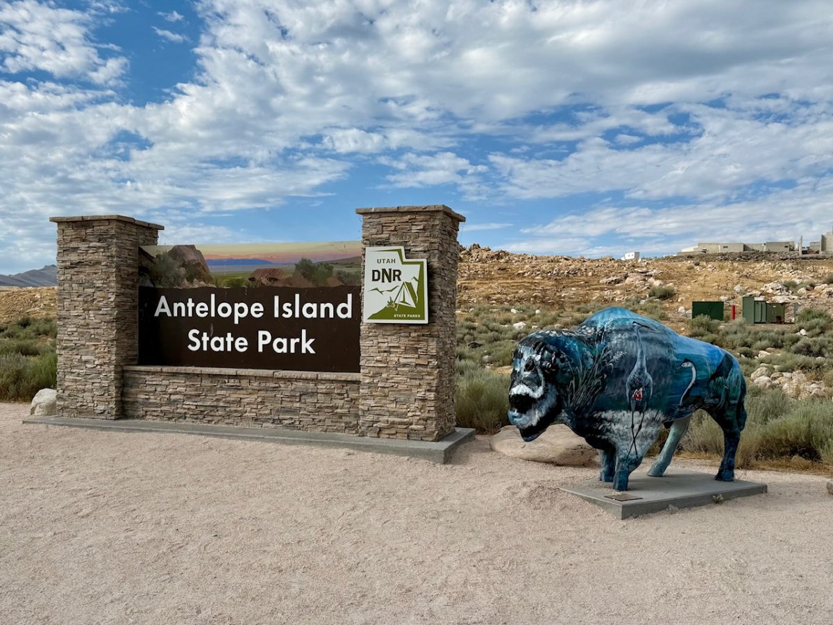 The entry sign for Antelope Island State Park with a buffalo statue