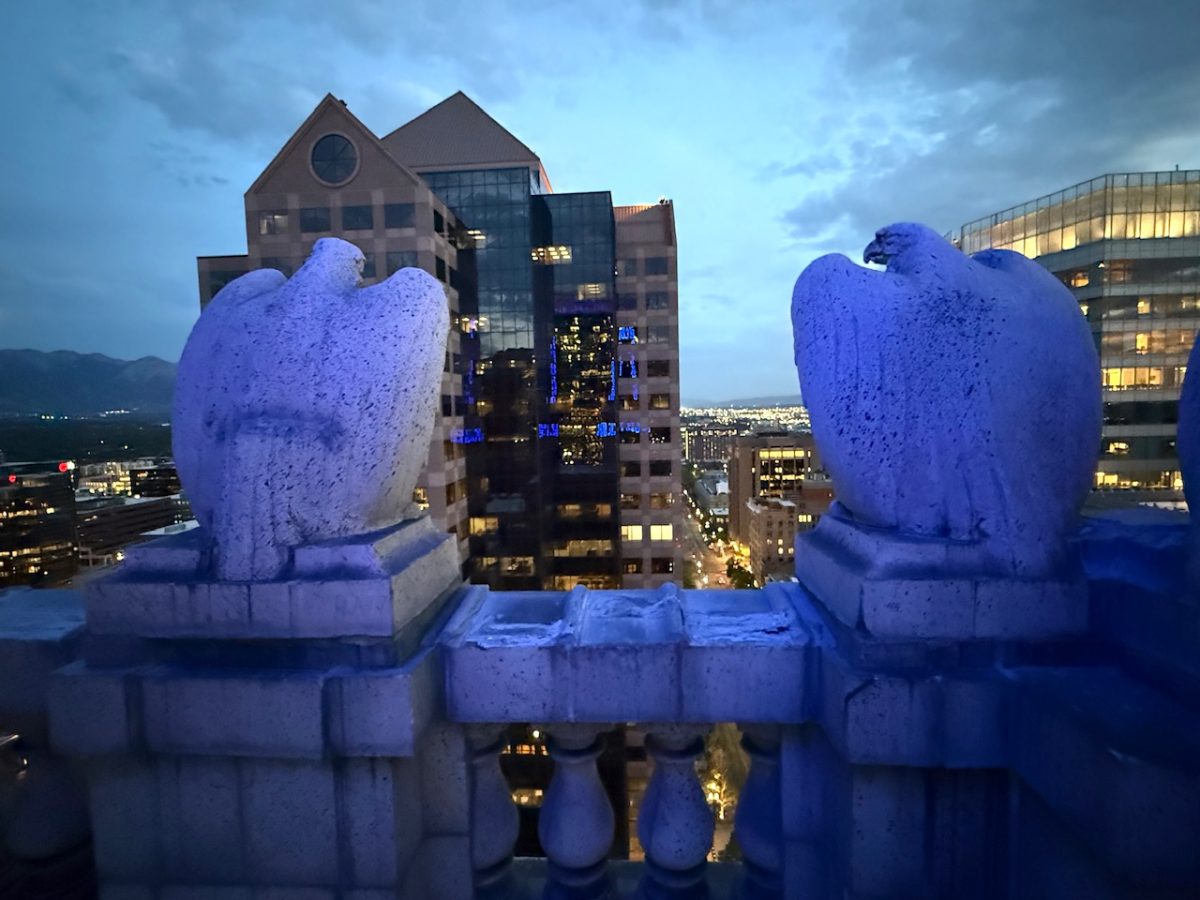 Stone eagles atop the Walker Center in Salt Lake City look out across to nearby buildings.  A rooftop tour of the Walker Center is one of the best things to do in Salt Lake City