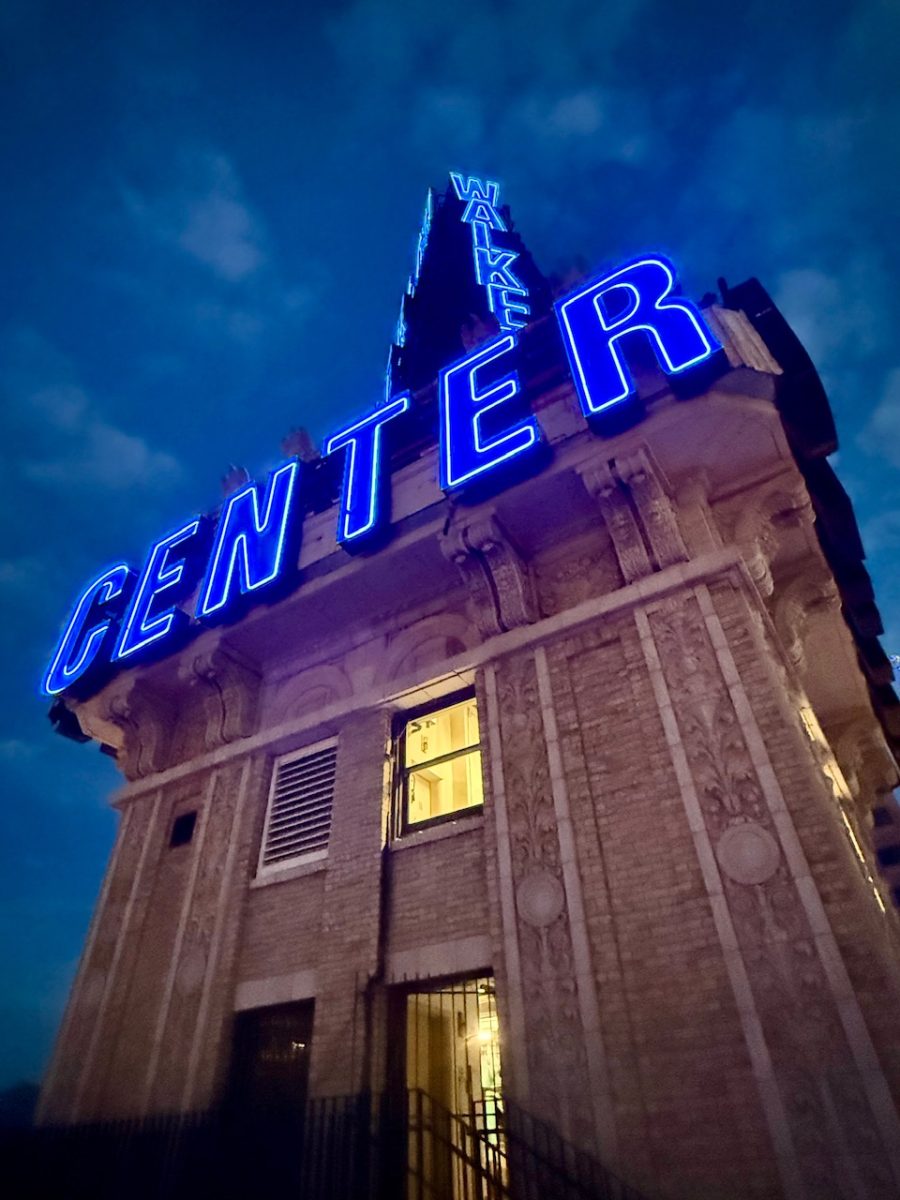 Looking up at the iconic Walker Center sign in Salt Lake City at dusk all lit up in blue