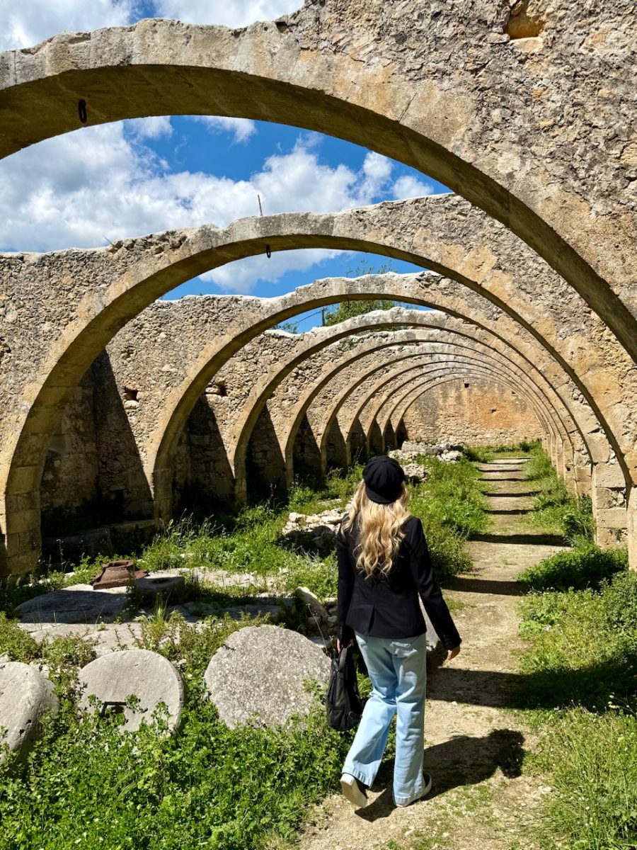 A woman walks through the ruins of an olive oil press at the St George Monastery near Vamos Crete